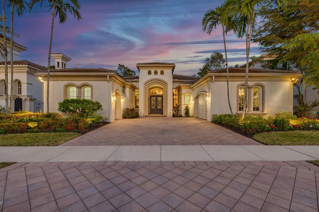 mediterranean / spanish home with a garage and french doors