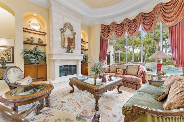 living room with built in shelves, a fireplace, and crown molding