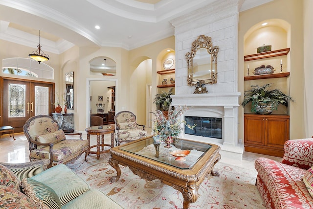 tiled living room featuring french doors, built in shelves, crown molding, a fireplace, and a high ceiling