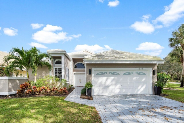 view of front of home with a garage and a front lawn