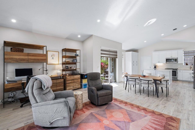 living room featuring light wood-type flooring and vaulted ceiling