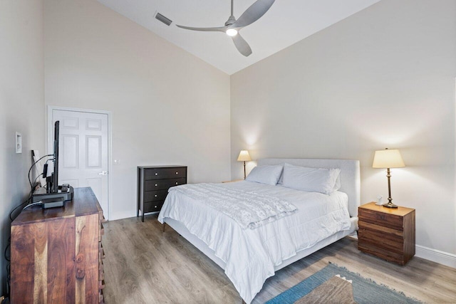 bedroom with wood-type flooring, a closet, high vaulted ceiling, and ceiling fan