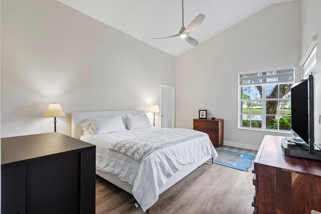 bedroom featuring ceiling fan, dark wood-type flooring, and high vaulted ceiling