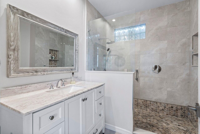 bathroom featuring a tile shower and vanity