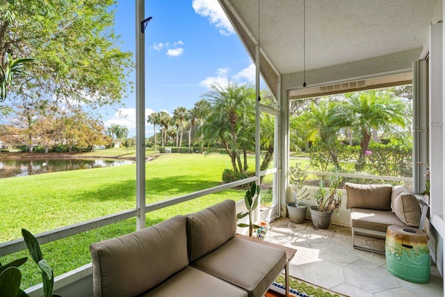 sunroom featuring a water view