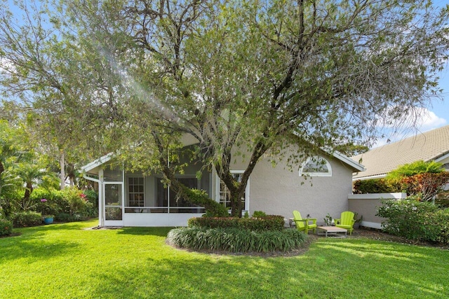 back of house with a sunroom and a yard