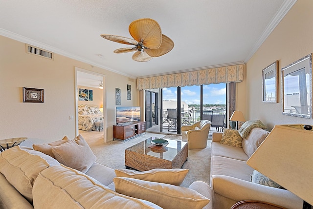 living room with crown molding, ceiling fan, and light carpet