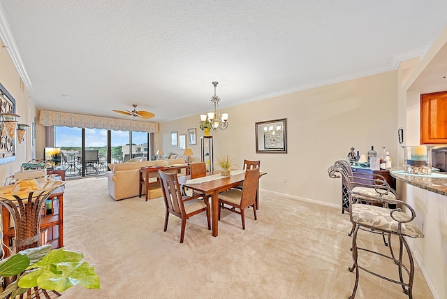 dining space featuring ceiling fan with notable chandelier, light colored carpet, ornamental molding, and a textured ceiling