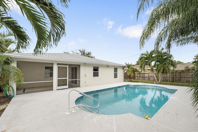 view of swimming pool featuring a sunroom and a patio