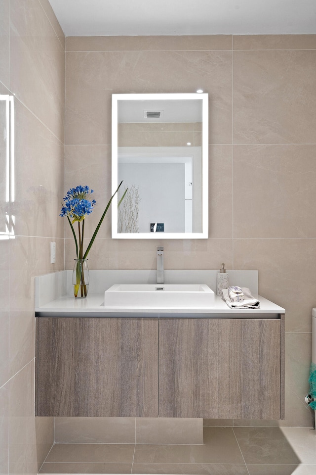 bathroom with tile walls, sink, and tile patterned floors