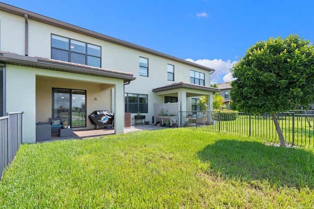 back of property with a patio and a lawn