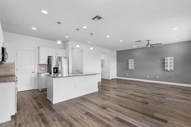 kitchen featuring a center island with sink, dark hardwood / wood-style flooring, stainless steel fridge with ice dispenser, white cabinetry, and decorative light fixtures