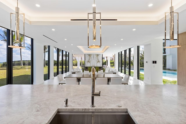 kitchen with sink, decorative light fixtures, and floor to ceiling windows