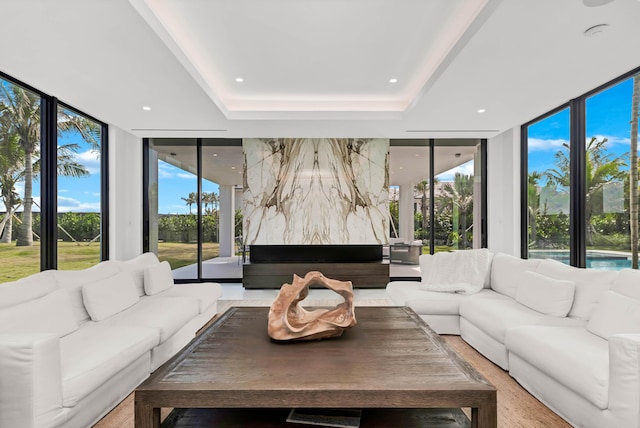 living room with expansive windows and a raised ceiling