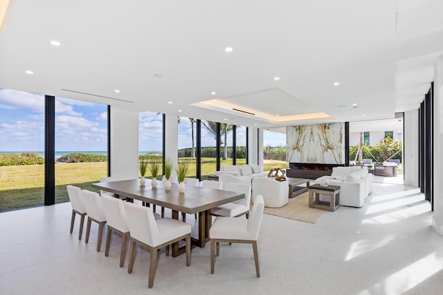 dining space featuring a raised ceiling and floor to ceiling windows