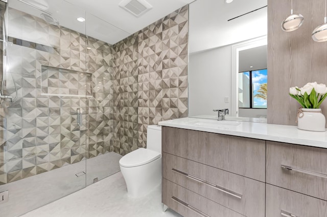 bathroom featuring tiled shower, vanity, and toilet