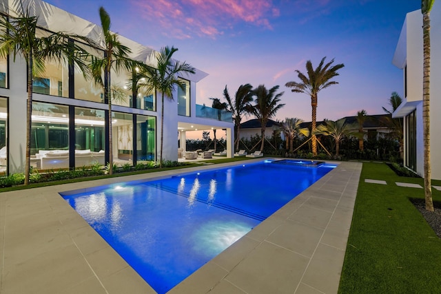 5 S Beach Rd, Jupiter Island, FL 33455 - pool at dusk featuring a pool with connected hot tub and a patio