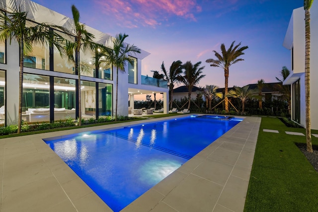 pool at dusk with a patio