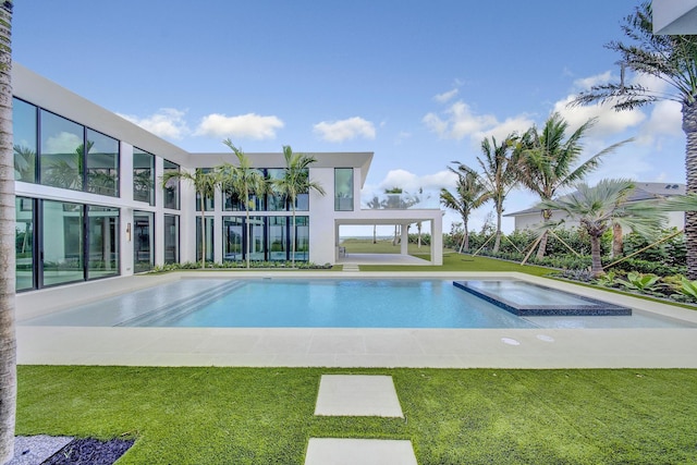 view of pool with a lawn and an in ground hot tub