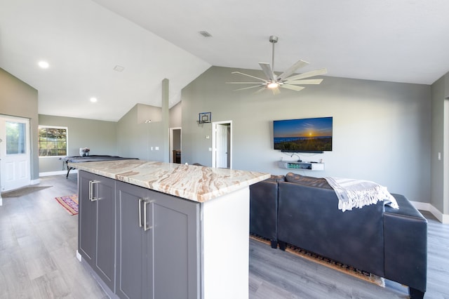 1441 NE 14th Ct Unit 4, Jensen Beach, FL 34957 - kitchen featuring open floor plan, a center island, gray cabinets, light wood-type flooring, and lofted ceiling