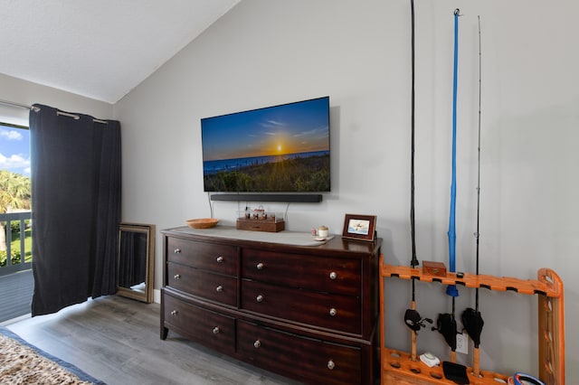 bedroom with access to exterior, light hardwood / wood-style flooring, and high vaulted ceiling