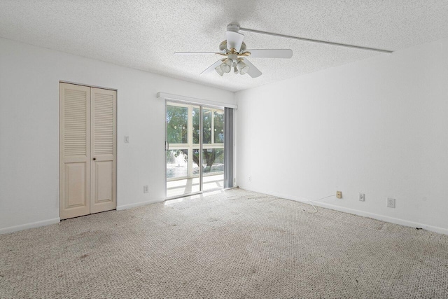 unfurnished room with a textured ceiling, ceiling fan, and carpet floors