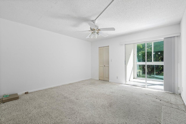 spare room featuring a textured ceiling, carpet flooring, and ceiling fan