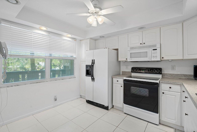 kitchen featuring white cabinetry, ceiling fan, white appliances, and a raised ceiling