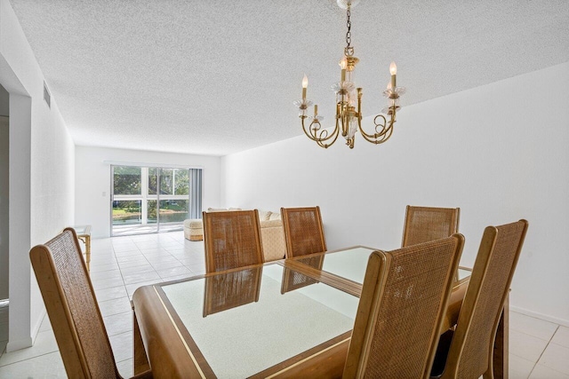 tiled dining area with a textured ceiling and a chandelier