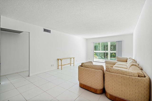 living room with a textured ceiling and light tile patterned floors