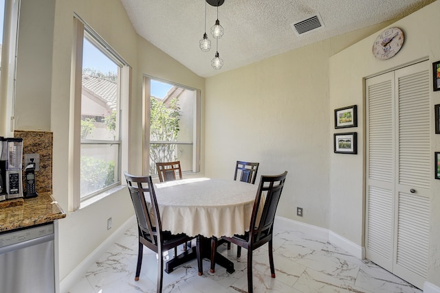 dining area with lofted ceiling and a textured ceiling