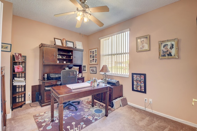 carpeted home office featuring ceiling fan and a textured ceiling