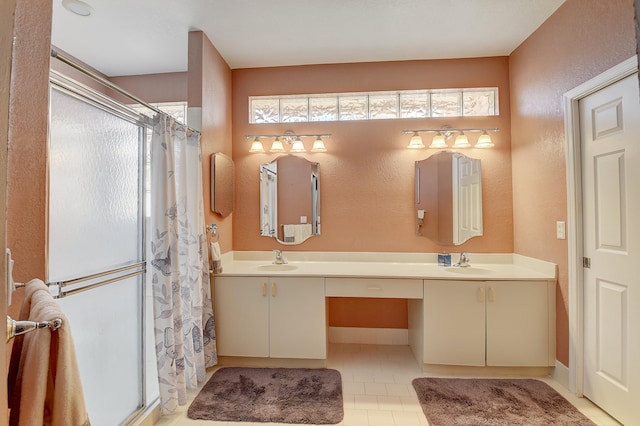 bathroom with a shower, vanity, and tile patterned floors