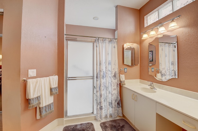 bathroom with walk in shower, vanity, and tile patterned flooring