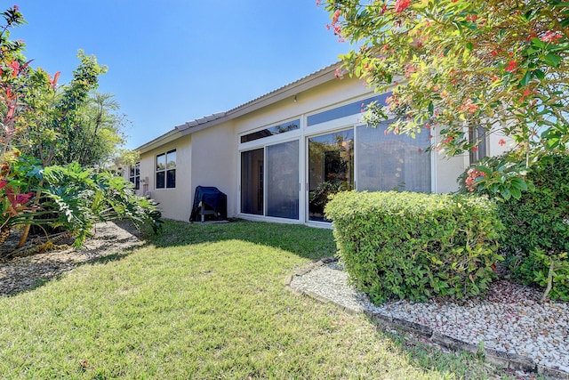 rear view of property featuring a lawn