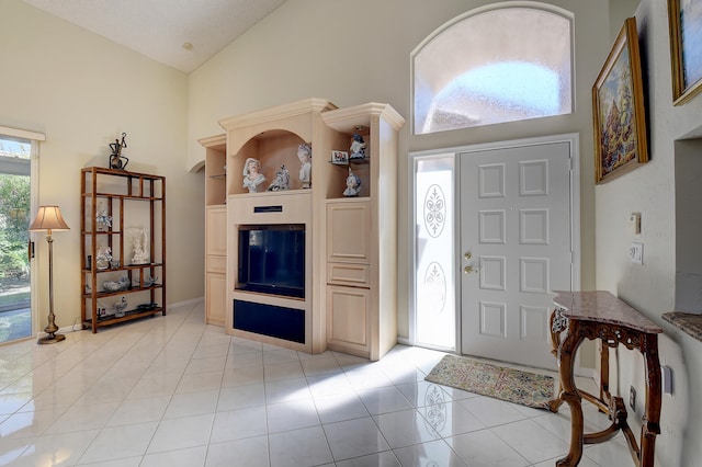 foyer entrance featuring light tile patterned floors and high vaulted ceiling