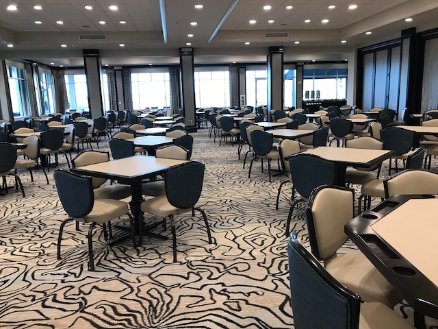 dining room featuring light carpet and a raised ceiling