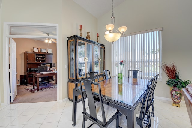 dining space featuring high vaulted ceiling, light tile patterned floors, and ceiling fan with notable chandelier