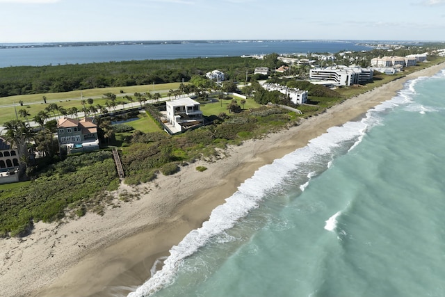 drone / aerial view featuring a water view and a view of the beach