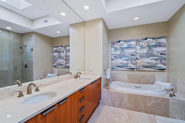 bathroom featuring tile patterned flooring, vanity, a skylight, and separate shower and tub