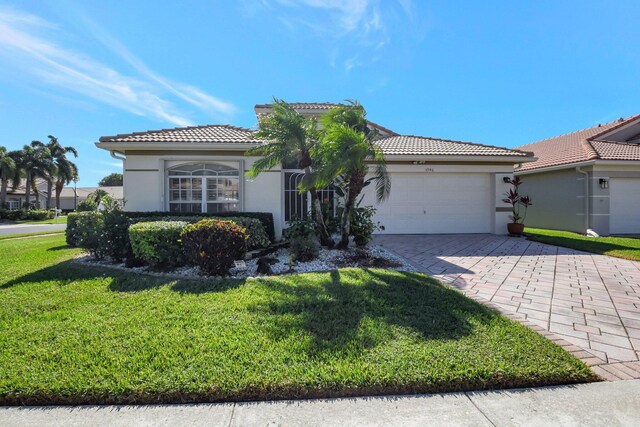 view of front of home with a garage, a front lawn, and central air condition unit