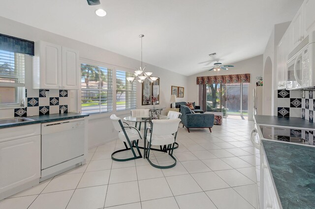 tiled living room featuring ceiling fan with notable chandelier