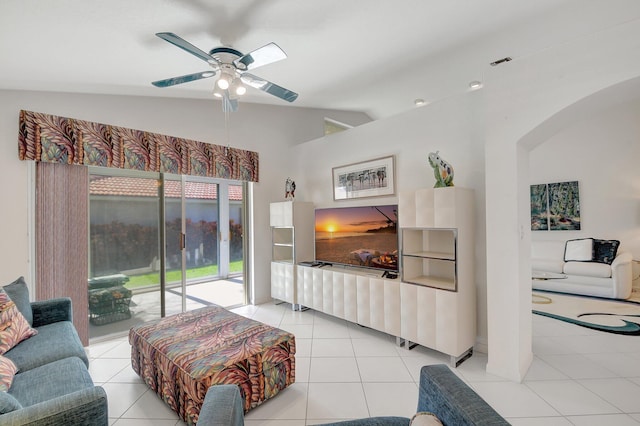 living room with light tile patterned floors, arched walkways, lofted ceiling, visible vents, and a ceiling fan