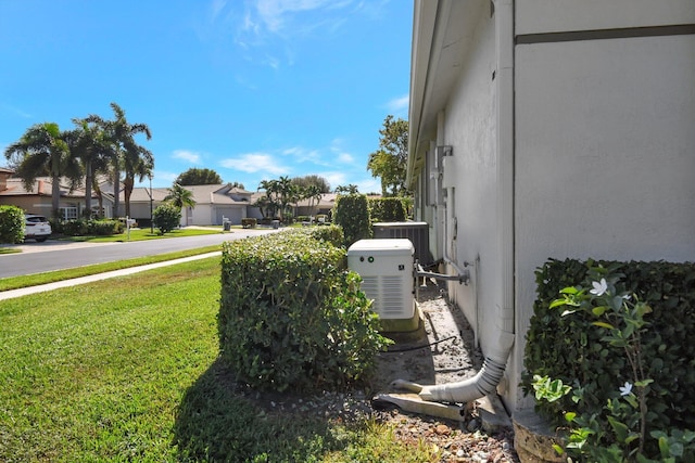 exterior space with a residential view, a yard, and central AC unit