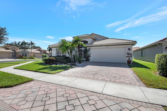 view of front of home featuring a residential view, decorative driveway, a front yard, and stucco siding