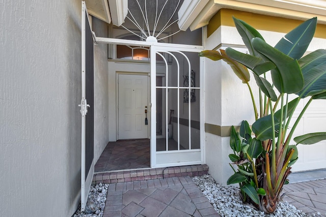 doorway to property featuring stucco siding