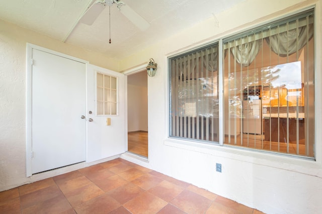 unfurnished sunroom featuring ceiling fan