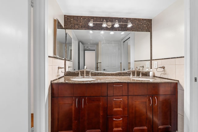 bathroom with vanity and tile walls