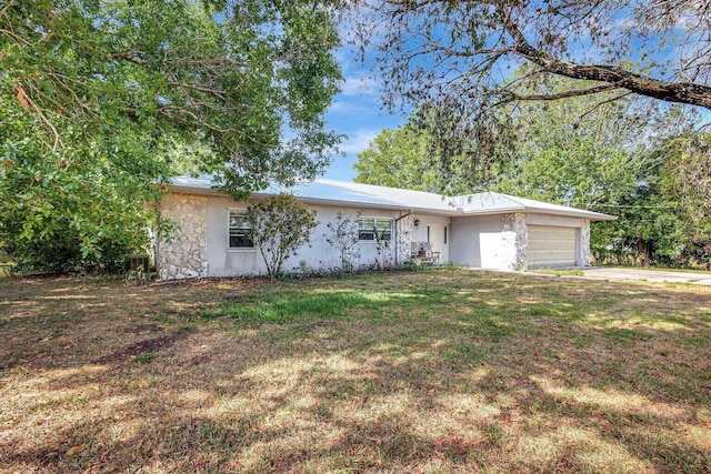 single story home featuring a garage and a front lawn