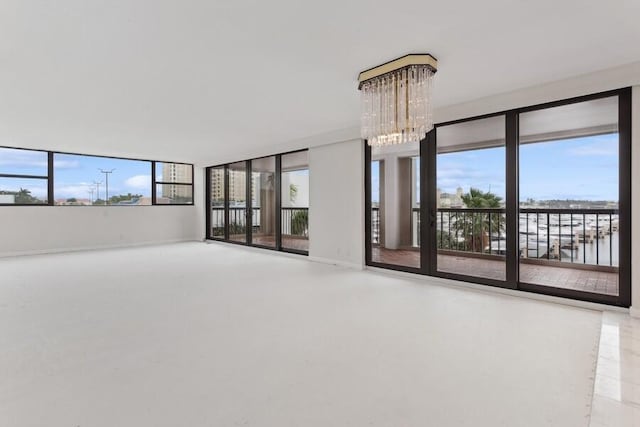 spare room featuring a water view and an inviting chandelier